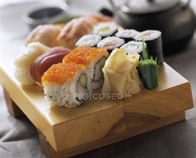 Assorted sushi on wooden board — Stock Photo
