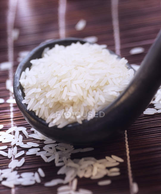 Schöpfkelle mit ungekochtem langen weißen Reis — Stockfoto