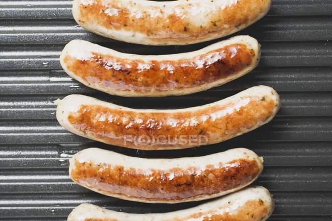 Fresh sausages on grill — Stock Photo