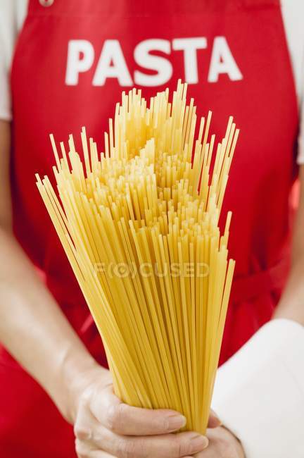 Жінка тримає купу сушених спагеті — стокове фото