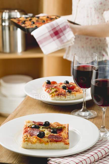 Pizza in Tellern und Wein — Stockfoto
