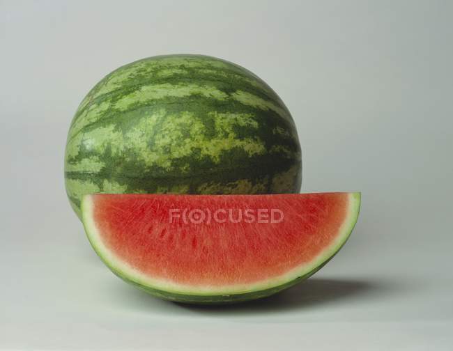 Wassermelonenkeil mit ganzer Wassermelone — Stockfoto