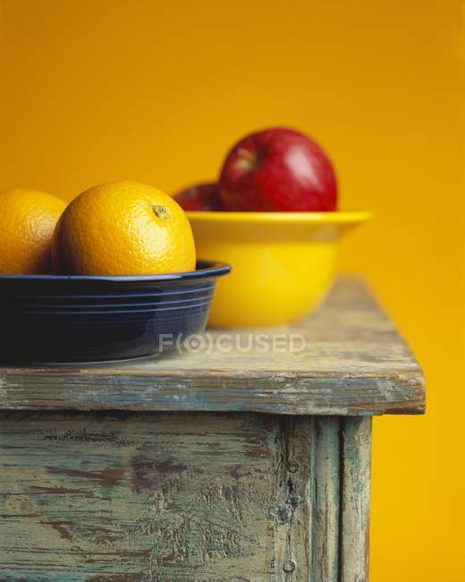 Oranges and apples in bowls — Stock Photo