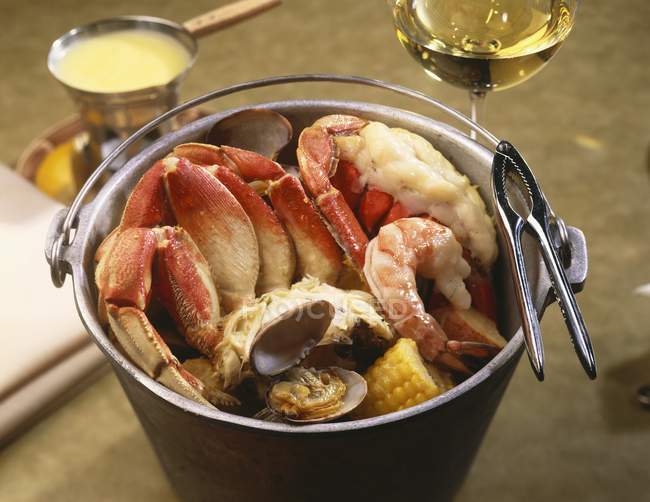 Closeup view of steamed seafood in pail with nutcracker — Stock Photo