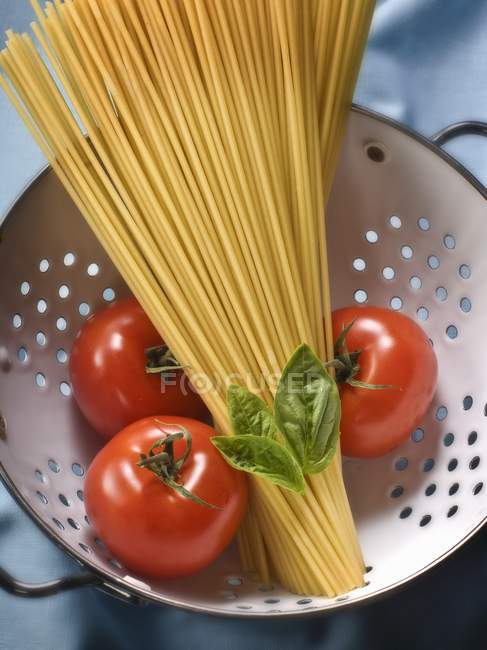 Bunch of dried spaghetti and tomatoes — Stock Photo