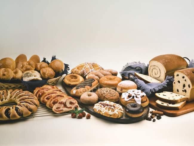 Variété de produits de boulangerie et de pâtisserie sur surface blanche — Photo de stock