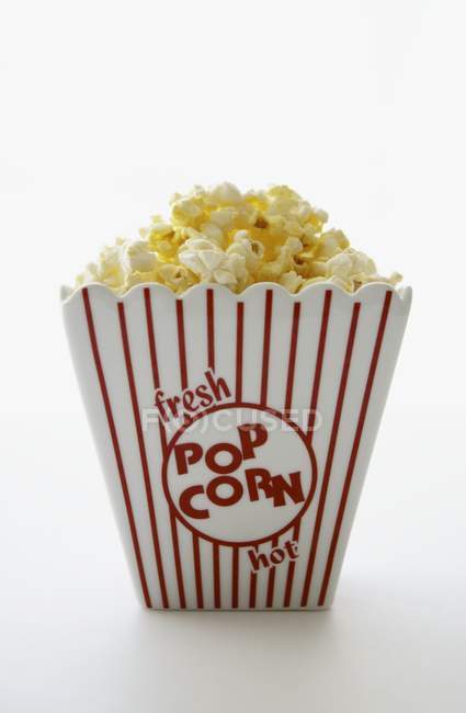 Gestreifter Behälter mit gebuttertem Popcorn — Stockfoto