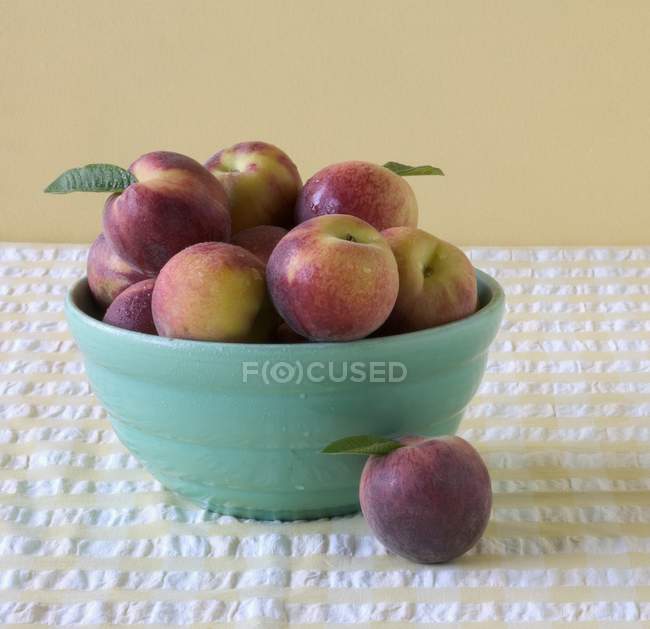 Свіжі персики в блакитній мисці — стокове фото