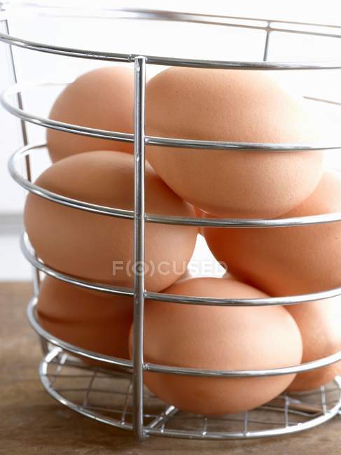 Huevos pardos en cesta - foto de stock