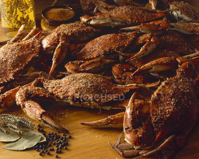 Closeup view of spiced whole crabs on wooden surface — Stock Photo