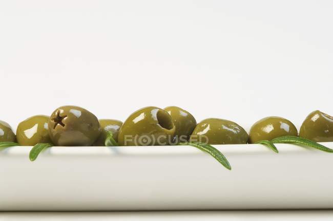 Зеленые оливки и розмарин — стоковое фото