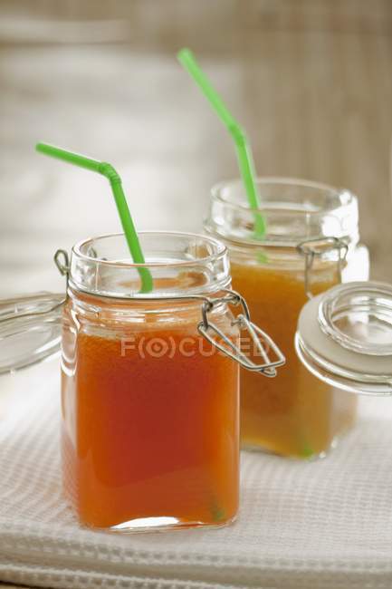 Peach juice in preserving jars — Stock Photo
