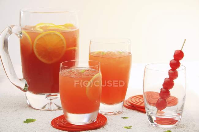 Ponche de frutas en vasos y una jarra de vidrio - foto de stock