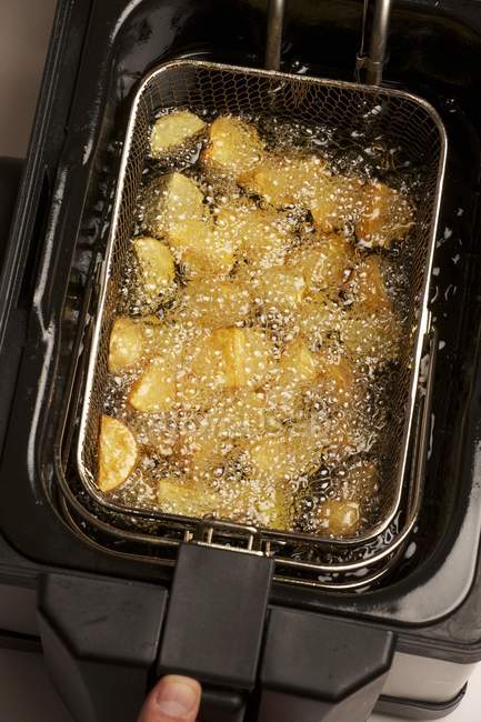 Potatoes pieces being fried — Stock Photo