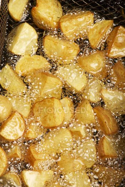 Potatoes pieces being fried — Stock Photo