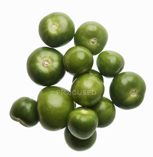 Beaucoup de Tomatillos verts crus sur fond blanc — Photo de stock