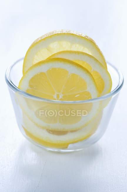 Rodajas de limón en tazón de vidrio - foto de stock