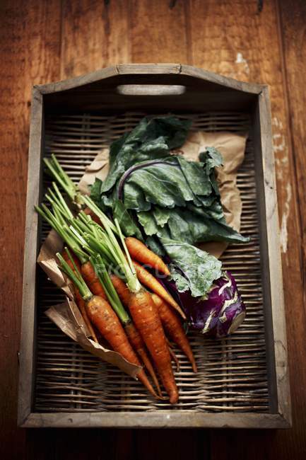 Cenouras e couve-rábano na bandeja de vime — Fotografia de Stock