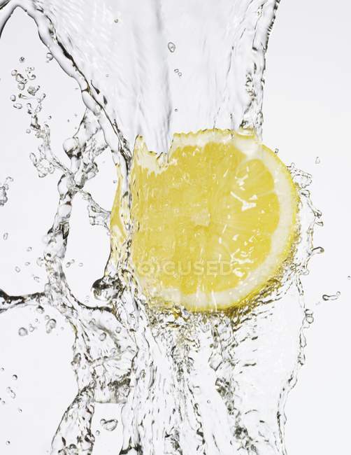 Eine halbe Zitrone unter fließendem Wasser — Stockfoto