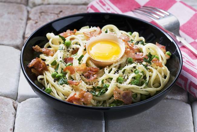 Espaguetis carbonara con tocino y huevo - foto de stock