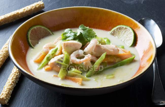 Coconut soup with salmon and prawns — Stock Photo