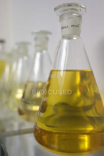 Vue rapprochée des liquides jaunes dans les bocaux de mesure — Photo de stock