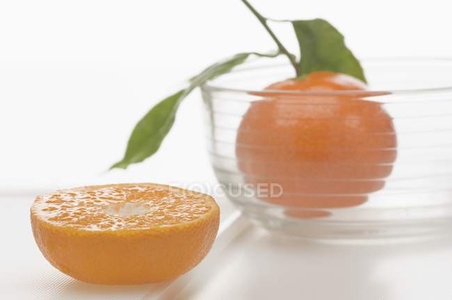 Mandarino in ciotola con metà — Foto stock