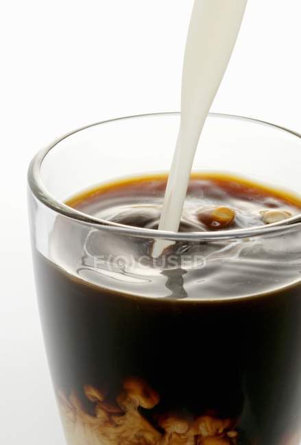 Сливки наливают в кофе — стоковое фото