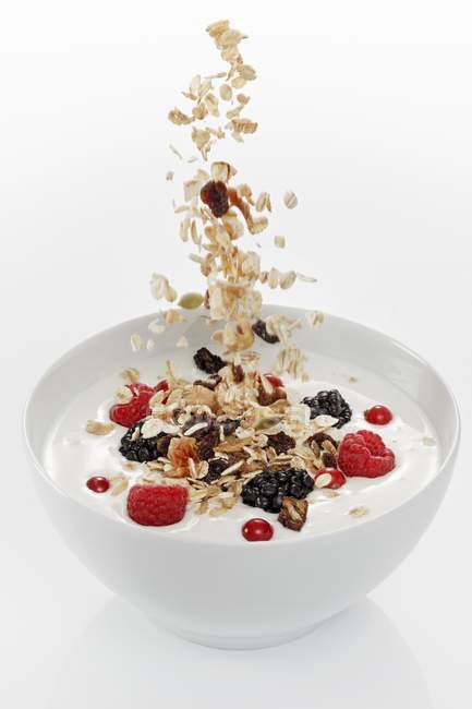 Muesli che cadono nello yogurt — Foto stock