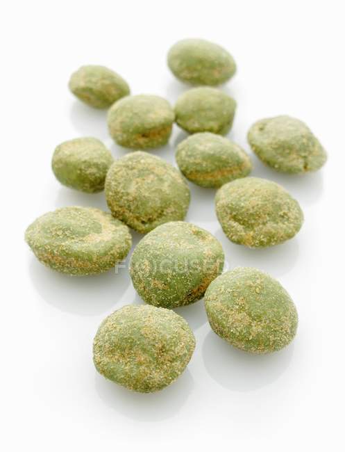Wasabi peanuts on white surface — Stock Photo