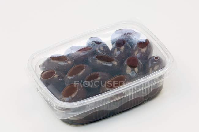 Olive nere in recipiente di plastica — Foto stock