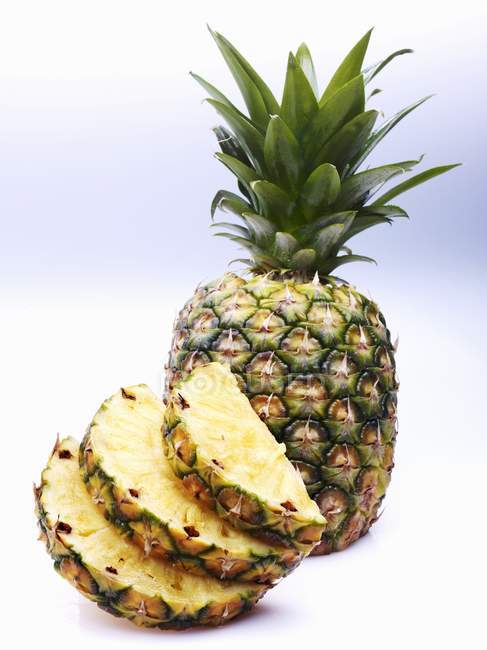 Pineapple slices and whole pineapple — Stock Photo
