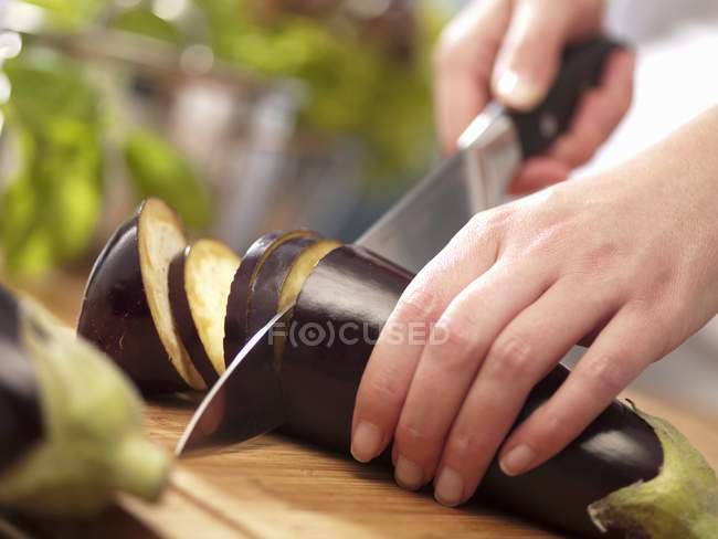 Mujer cortando berenjena - foto de stock