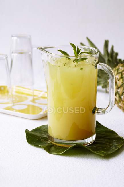 Pichet en verre de jus d'ananas menthe — Photo de stock