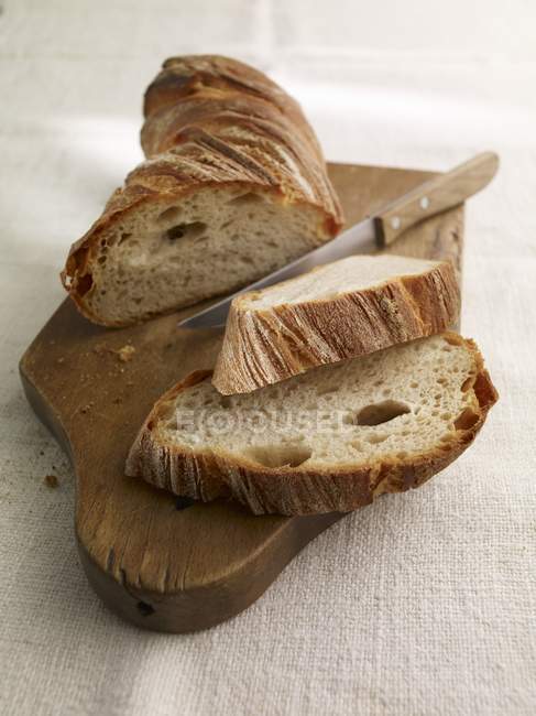 Partly sliced country baguette — Stock Photo