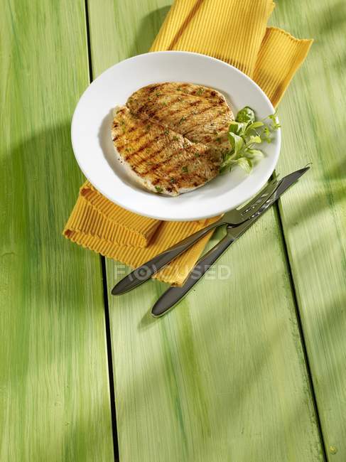 Vue surélevée de l'escalope de dinde grillée avec herbe sur plaque — Photo de stock