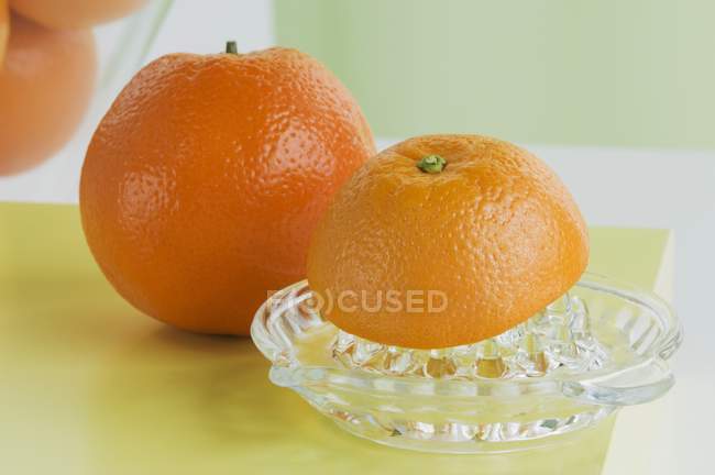 Апельсины с цитрусовым прессом — стоковое фото