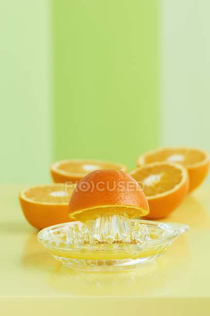 Mitades de naranja con exprimidor - foto de stock