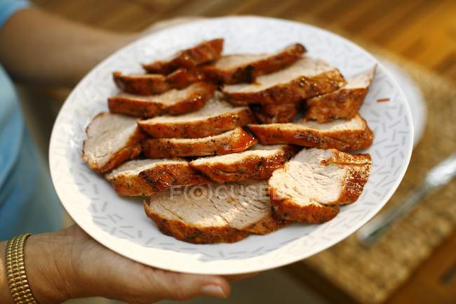 Donna che tiene piatto di filetto di maiale — Foto stock