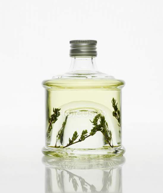 Vista close-up de vinagre de tomilho em garrafa de vidro — Fotografia de Stock