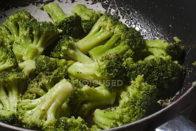 Brócolis refogados em uma frigideira na cozinha — Fotografia de Stock