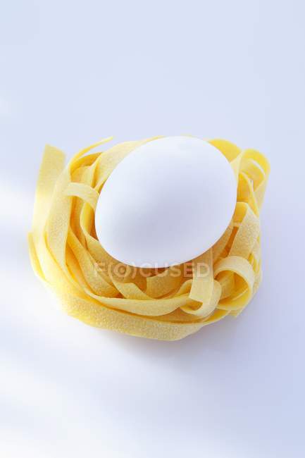 Fresh egg on tagliatelle — Stock Photo