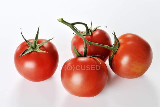 Cuatro tomates maduros de vid - foto de stock