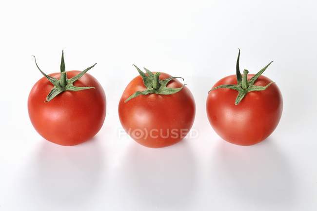 Tres tomates rojos - foto de stock