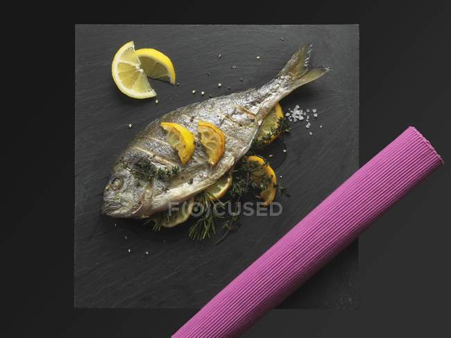 Fried bream with lemons and herbs — Stock Photo