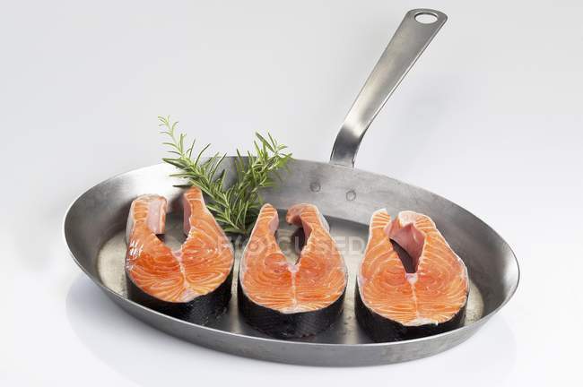 Fresh salmon steaks in frying pan — Stock Photo