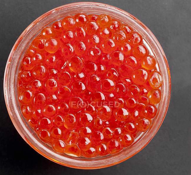 Caviar de salmón en un tazón de vidrio - foto de stock