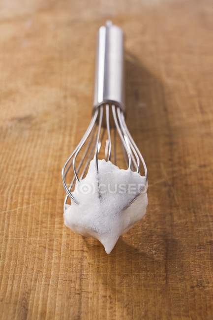 Closeup view of beaten egg white on whisk — Stock Photo
