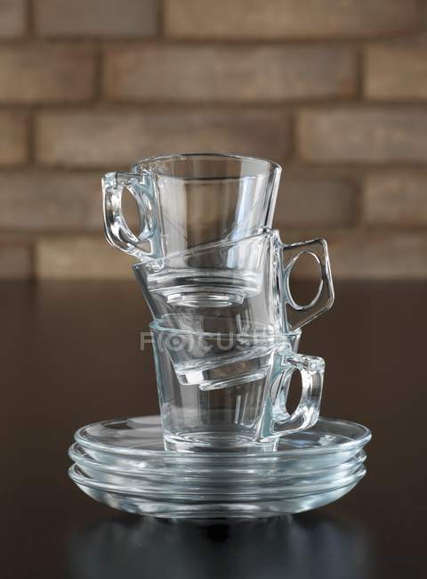 Closeup view of stacked glass cups and saucers — Stock Photo