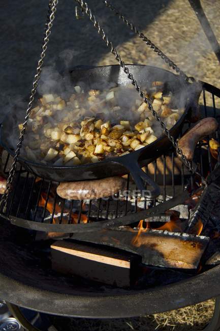 Potatoes and brats cooking — Stock Photo